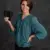 Person holding a black object against a dark background.