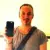 Person holding a smartphone, smiling brightly.
